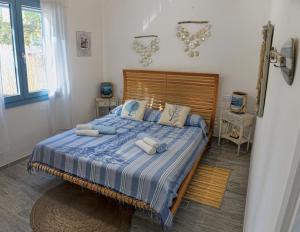 um quarto com uma cama com lençóis e almofadas azuis em Casa Cristina em Porto Pino
