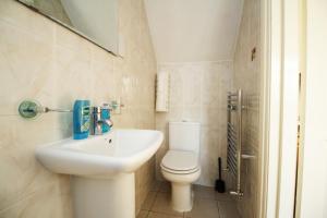 a white bathroom with a toilet and a sink at Flexistay Tooting Studios in London