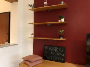 Zimmer mit einer roten Wand und Holzregalen in der Unterkunft DORA Rooms and terrace, Parco Dora in Turin