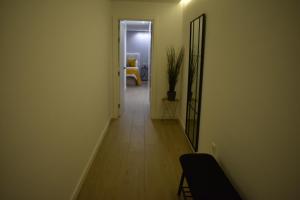a hallway with a mirror and a chair in a room at Strada-Beach Las Canteras in Las Palmas de Gran Canaria