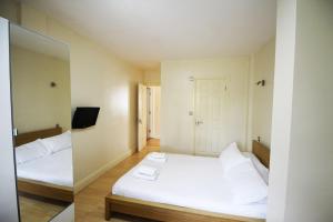 a bedroom with two beds and a mirror at Flexistay Tooting Studios in London