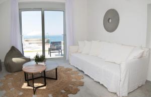 a living room with a white couch and a table at Elements Villas in Lardos