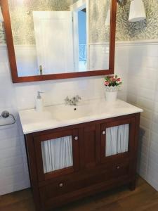 uma casa de banho com um lavatório e um espelho em La casa de verano Cudillero em Cudillero