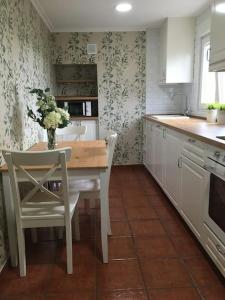 una cucina con tavolo e vaso di fiori di La casa de verano Cudillero a Cudillero