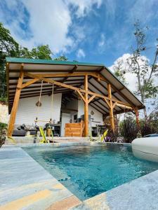 een zwembad met een paviljoen naast een huis bij Villa Kara in Grand-Bourg