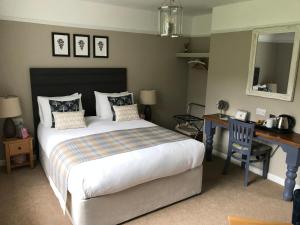 a bedroom with a bed and a desk and a desk at Oak Tree Lodge & Holiday Parking in Burstow