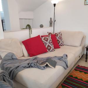 a white couch with colorful pillows on it at Sunkissed and Seasalted House in Melission