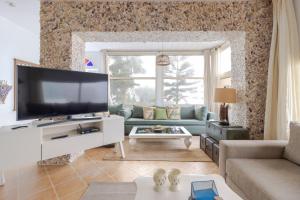 uma sala de estar com uma grande televisão de ecrã plano em Maison Simonetta em Oualidia