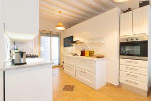 a kitchen with white cabinets and a stove at Maison Simonetta in Oualidia