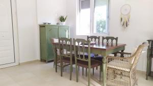 a dining room with a wooden table and chairs at Sunkissed and Seasalted House in Melíssion