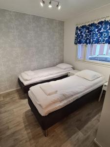 two twin beds in a room with a window at Home nest in Seinäjoki