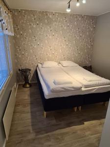 1 dormitorio con 1 cama y una pared con flores en Home nest, en Seinäjoki
