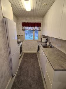 małą kuchnię z białymi urządzeniami i oknem w obiekcie Home nest w mieście Seinäjoki