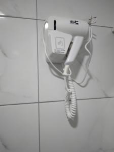 un teléfono colgado en una pared en un baño en Vila Silia, en Skopje