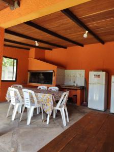 a kitchen with a table and chairs and a refrigerator at Casa BELLAGIO in Barra del Chuy