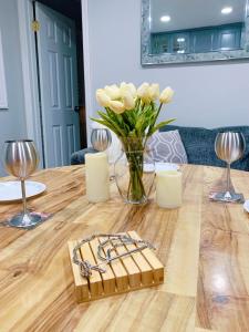 un jarrón de flores blancas sentado en una mesa de madera en SALE!! Brick City Bungalow 20 mins from NYC!!, en Newark