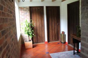 a hallway with two wooden doors and a potted plant at Villa La F in Guasca