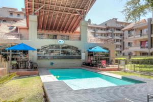 a swimming pool in front of a building at Glammys @77 Grayston Drive in Johannesburg