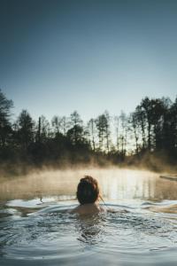 una mujer nadando en un cuerpo de agua en NaturApartments & Spa en Burg (Spreewald)