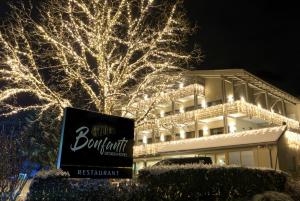 Un edificio con luci di Natale davanti a un albero di Bonfanti Design Hotel a Chienes