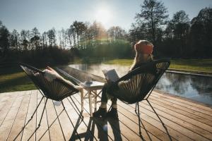 Eine Frau, die an einem Tisch mit einem Buch sitzt. in der Unterkunft NaturApartments & Spa in Burg