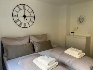 een slaapkamer met een grote klok en handdoeken op een bed bij Gemütliche Wohnung mit Gartenblick in Innsbruck
