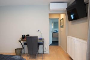 um quarto com uma secretária e uma televisão num quarto em B&B Maaltebrug em Gent
