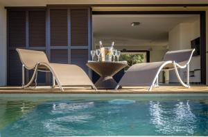 2 sillas y una mesa junto a la piscina en Résidence Manon en Monticello