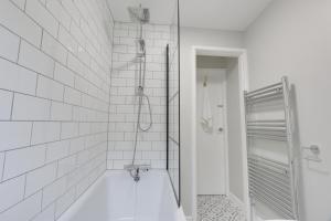 a white bathroom with a tub and a shower at Springvale in Sheffield