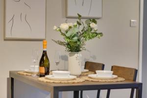 a table with a bottle of wine and a vase of flowers at Springvale in Sheffield