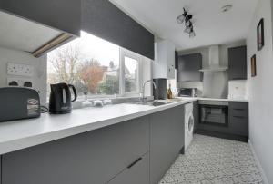 a white kitchen with a sink and a window at Springvale in Sheffield +16 photos