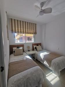 1 dormitorio con 2 camas y ventana en Casa Palmera - El Bosque - Playa Flamenca en Playa Flamenca