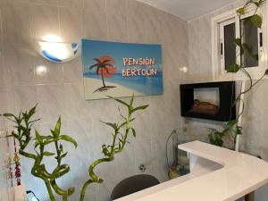 Baño con una palmera en la pared en Pensión Bertolín, en Barcelona