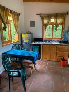 a kitchen with a table and two chairs and a stove at Lake Front Cabin in Santa Cruz La Laguna