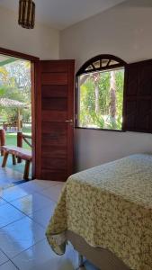 バーハ・グランデにあるCasa Praia dos Anjosのベッドルーム1室(ベッド1台、大きな窓付)