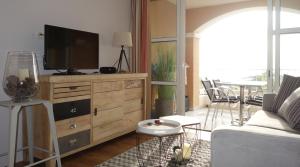 a living room with a television on a wooden dresser at Cap Estérel Agay St Raphaël vue mer in Agay - Saint Raphael