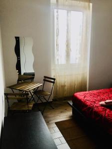 sypialnia z łóżkiem i oknem ze stołem i krzesłami w obiekcie Roma House Alessandrino w Rzymie
