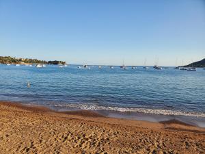 a beach with a bunch of boats in the water at Village Cap Estérel Agay St Raphaël vue mer et piscine in Agay - Saint Raphael