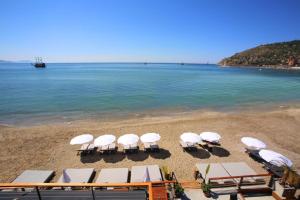 eine Gruppe von Stühlen und Sonnenschirmen am Strand in der Unterkunft 2-Room Accommodation in a Luxury Resort in Alanya