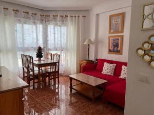 プエルト・デ・ラ・クルスにあるVista Rosmaryのリビングルーム(赤いソファ、テーブル付)