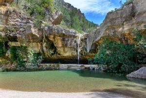 een waterval aan de kant van een berg met groen water bij CASA BAUTISTA - ROTGLÀ in Rotglá y Corbera
