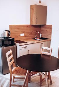Una cocina con una mesa y dos sillas y un fregadero. en L&B Szczyrk Centrum, en Szczyrk