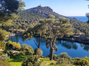 a view of a lake with a castle on a hill at Village Cap Estérel Agay St Raphaël vue mer et piscine in Agay - Saint Raphael