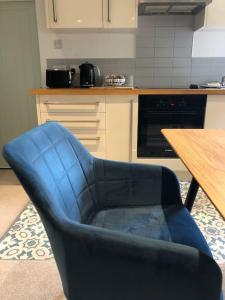 a blue chair in a kitchen next to a table at Hideaway between Coast and Moors in a beautiful Village apartment in Sleights