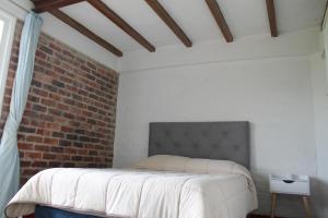 a bed in a room with a brick wall at Villa La F in Guasca