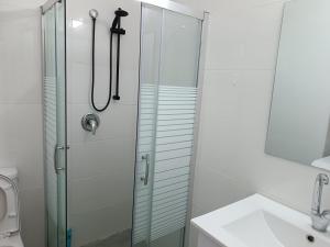 La salle de bains est pourvue d'une douche avec une porte en verre. dans l'établissement דירות אירוח לכל מטרה, à Beer-Sheva