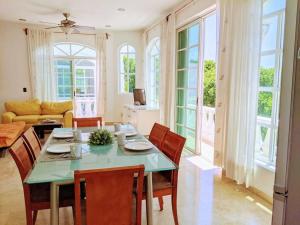 a dining room with a table and chairs and a couch at 18br up to 50guest Castillos Playacar walk to Beach and 5th Ave 1000Mbps in Playa del Carmen