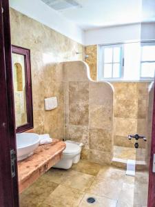 a bathroom with a sink and a toilet and a shower at 18br up to 50guest Castillos Playacar walk to Beach and 5th Ave 1000Mbps in Playa del Carmen