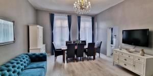 ein Wohnzimmer mit einem blauen Sofa und einem Esszimmer in der Unterkunft Apartament Kaczyniec 10 in Gliwice