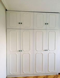 um armário branco com quatro portas num quarto em Disfruta de la naturaleza en el centro de Asturias em Siero